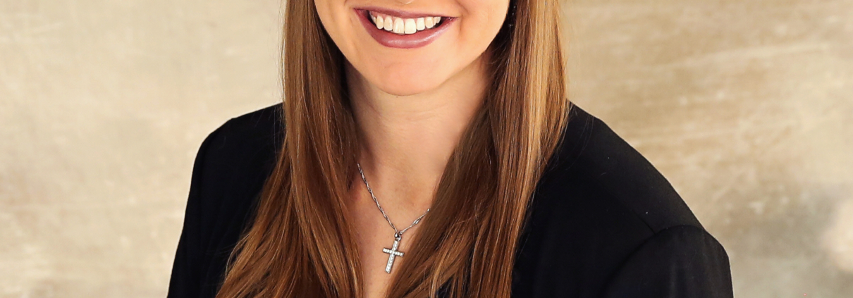 Renae Keller wears a black blazer in front of a tan background.